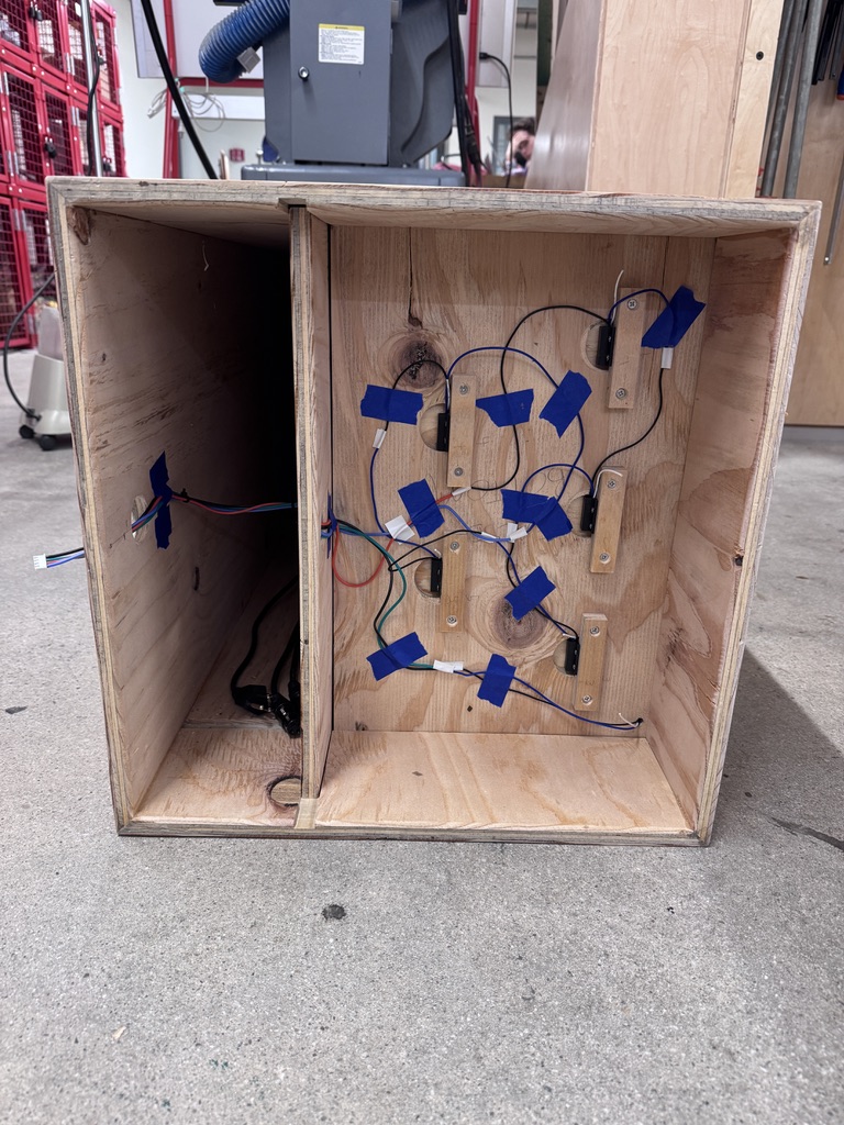 Reed switches in the cabinet's base detect placement of another prop, integrating with COGS to generate an effect